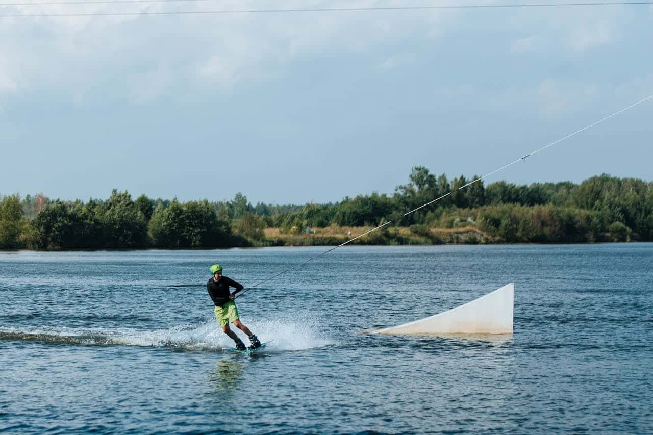 Vandens pramogos Kaune: vandenlentėmis skriejantis sportininkas aktyviam poilsiui Kauno marių pakrantėje.