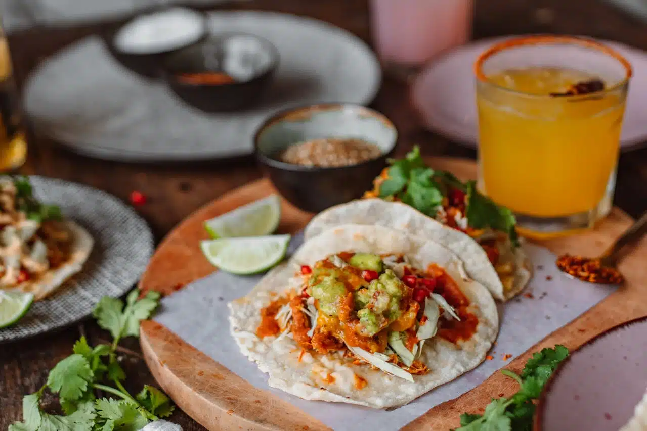 Tacos Vilniuje – spalvingi meksikietiški takai su gvakamole, lime skiltelėmis ir gaiviu kokteiliu šalia.