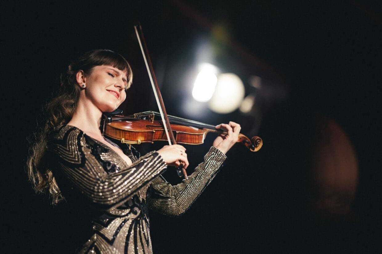 Smuikininkė Ieva Pranskutė groja scenoje, jos muzika jungia Lietuvos tradicijas ir pasaulinę sceną vienoje erdvėje