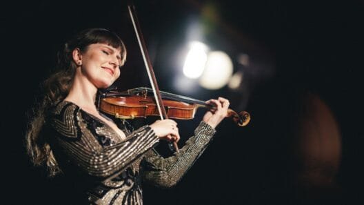 Smuikininkė Ieva Pranskutė groja scenoje, jos muzika jungia Lietuvos tradicijas ir pasaulinę sceną vienoje erdvėje