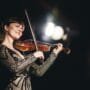 Smuikininkė Ieva Pranskutė groja scenoje, jos muzika jungia Lietuvos tradicijas ir pasaulinę sceną vienoje erdvėje