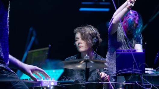 Interviu su Aiste Kalvelyte, kuri energingai groja būgnais gyvo garso koncerto metu.