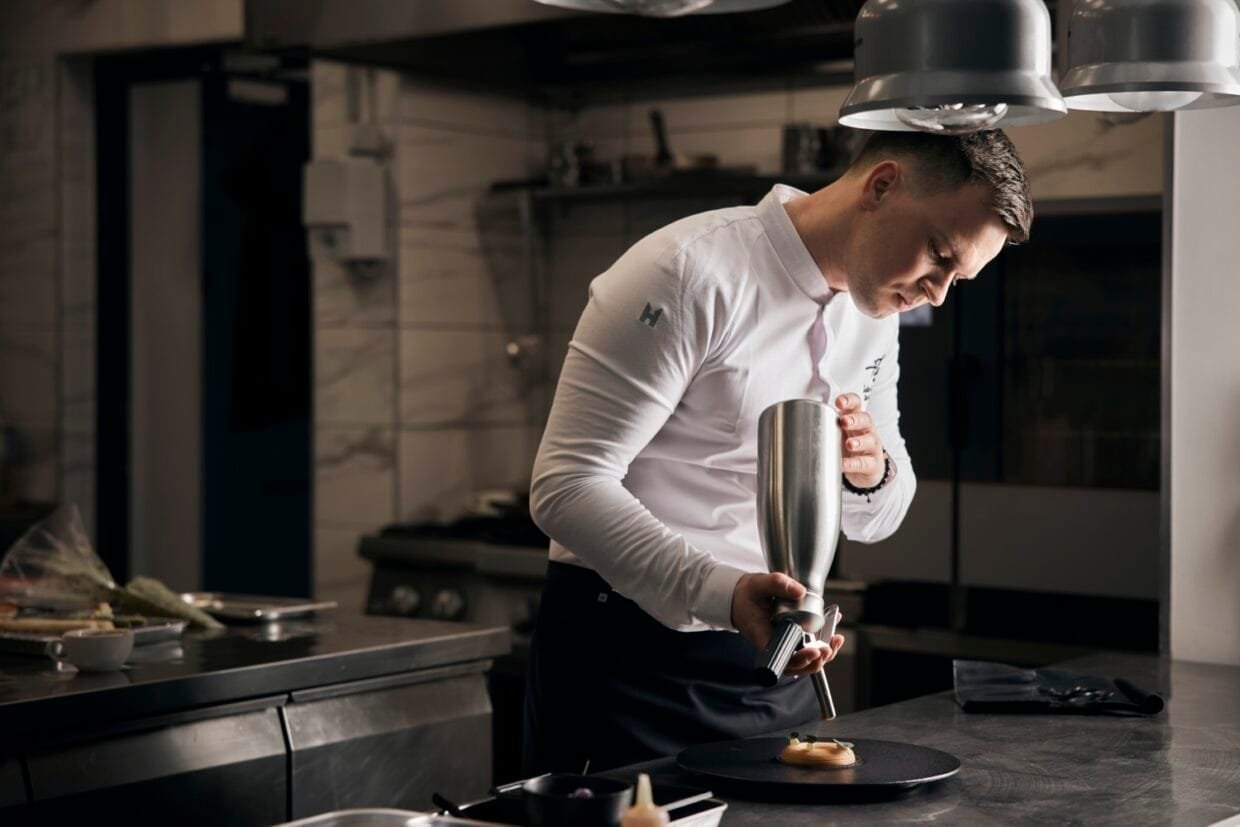 irtuvės šefas Lukas Gaudutis susikaupęs ruošia patiekalą restorano virtuvėje Plungėje.