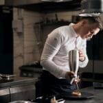 irtuvės šefas Lukas Gaudutis susikaupęs ruošia patiekalą restorano virtuvėje Plungėje.