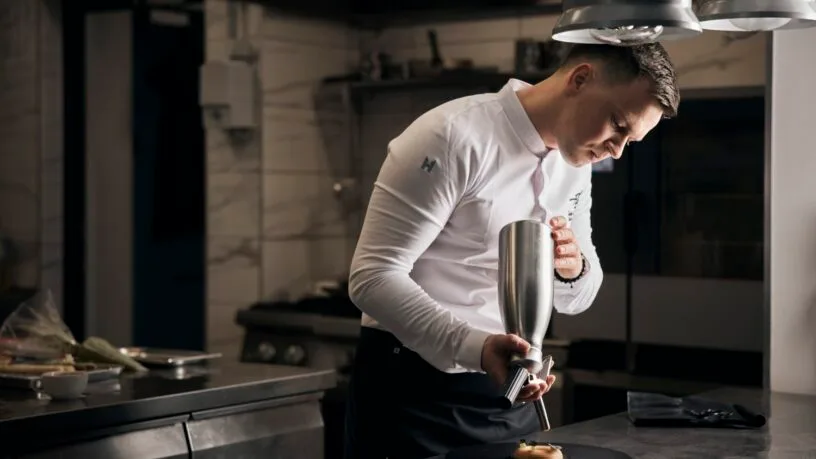 irtuvės šefas Lukas Gaudutis susikaupęs ruošia patiekalą restorano virtuvėje Plungėje.