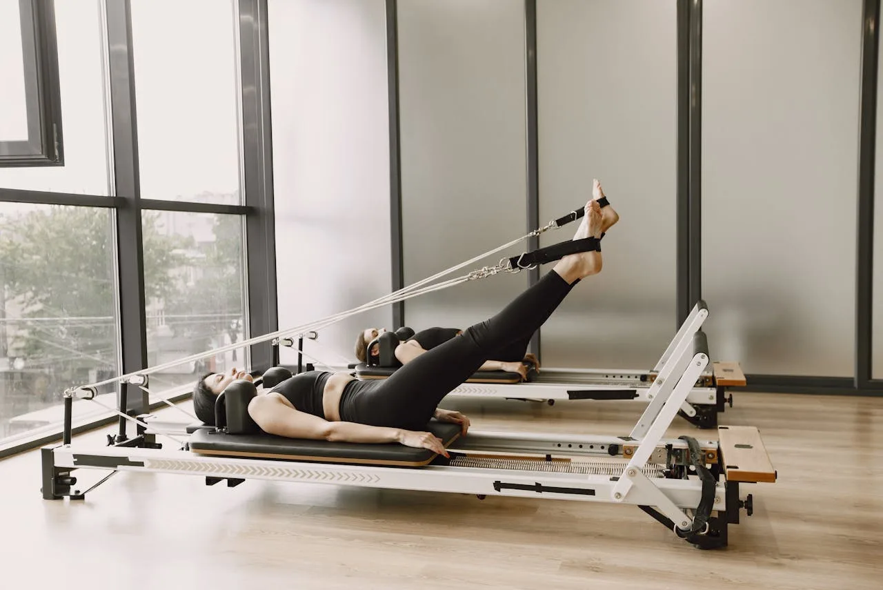 Reformer pilates Vilniuje - įranga studijoje, paruošta treniruotei su spyruoklėmis ir platforma.