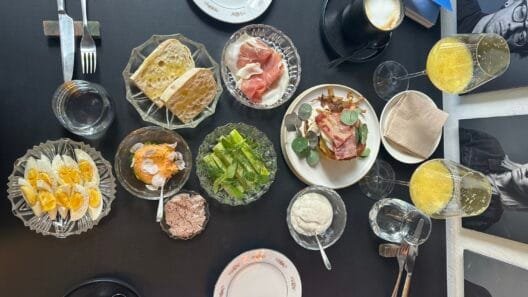 Maisto apžvalgininkė Šefo Tarka restorane prie stalo su įvairiais patiekalais.