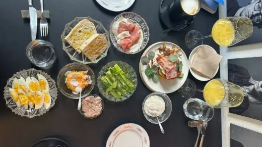 Maisto apžvalgininkė Šefo Tarka restorane prie stalo su įvairiais patiekalais.