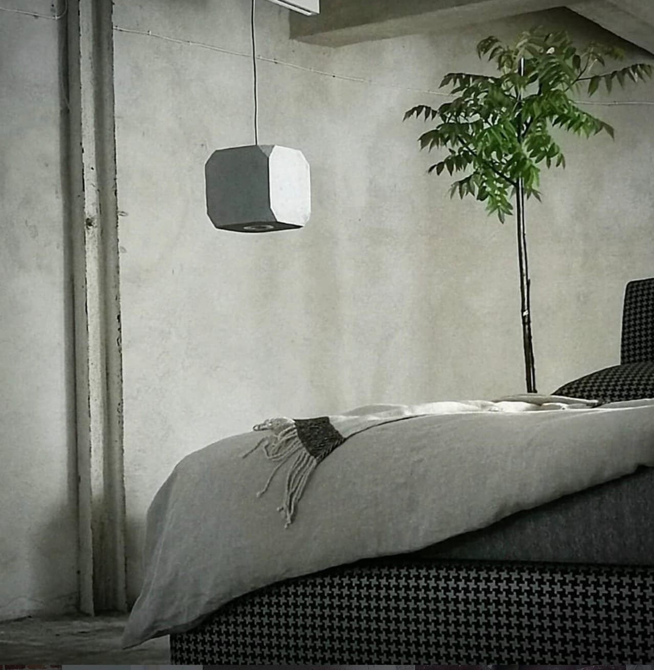 Pilkas tekstūrinis šviestuvas, pagamintas iš perdirbto popieriaus, primenantis betoną.