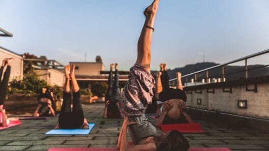 Jogos stovyklos Lietuvoje - moteris praktikuoja asanas ramybėje prie Neries upės Zen Miško erdvėje.