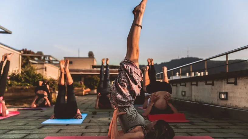 Jogos stovyklos Lietuvoje - moteris praktikuoja asanas ramybėje prie Neries upės Zen Miško erdvėje.