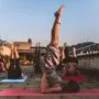 Jogos stovyklos Lietuvoje - moteris praktikuoja asanas ramybėje prie Neries upės Zen Miško erdvėje.