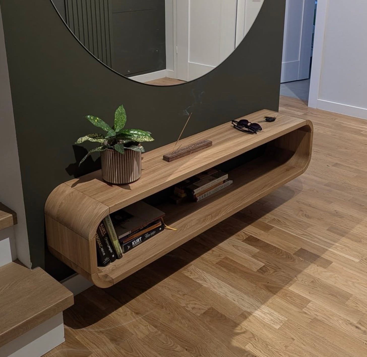 Minimalistinis natūralaus ąžuolo kavos staliukas šviesiame svetainės interjere.