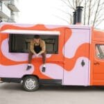 „Flying Tomato Pizza“ įkūrėjas Nikolai Oženka prie savo pirmojo raudono maisto furgonėlio.