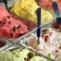 Spalvingos ledainės Vilniuje vitrina su šviežiais itališkais „gelato“ desertais ir besišypsančiais lankytojais.