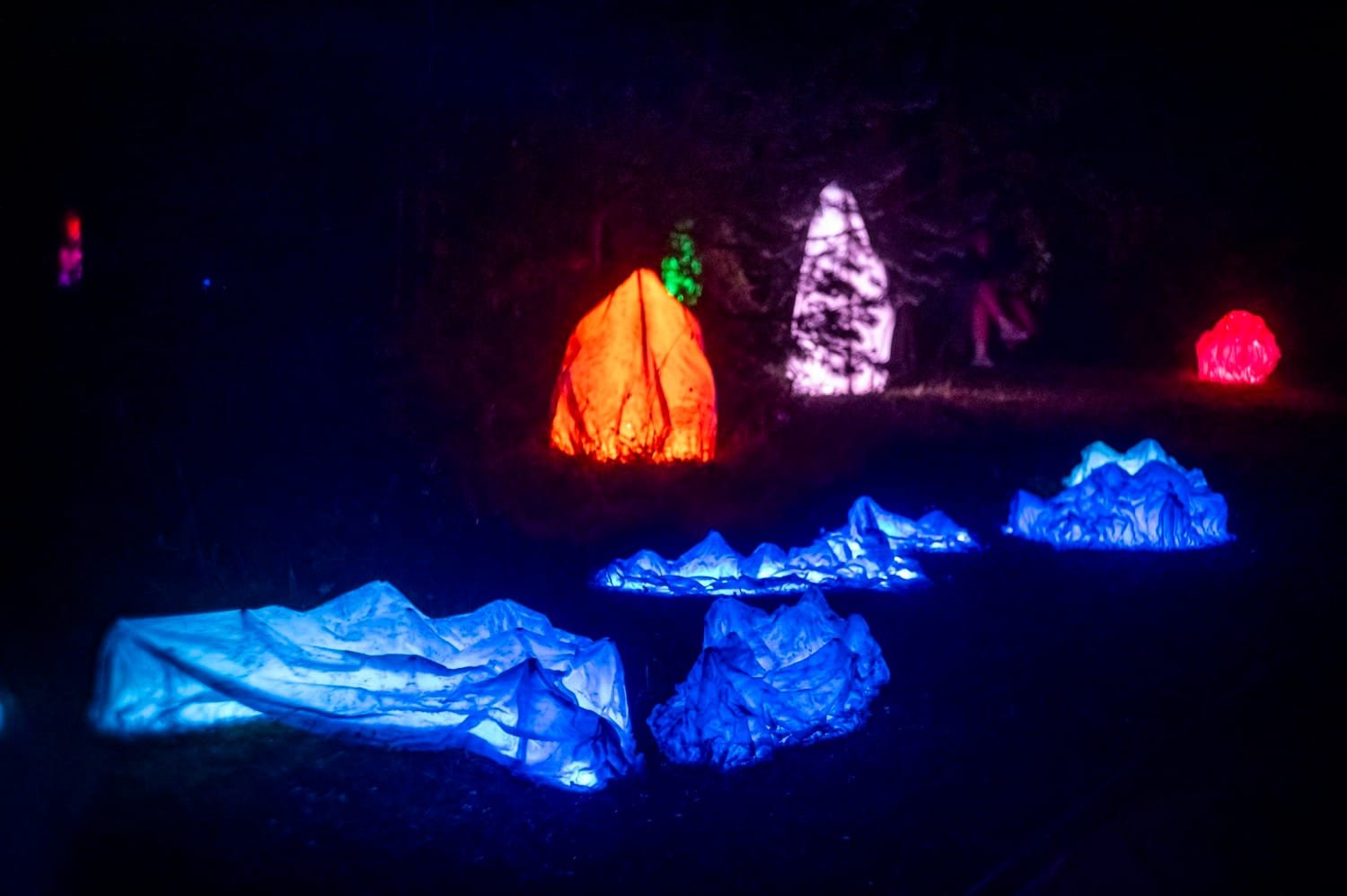 Atmosferinis elektroninės muzikos koncertas ir lazerių šviesos naktinėje scenoje.