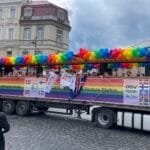 Vaivorykštės vėliavomis pasipuošę žmonės žygiuoja Vilniaus gatvėmis solidarumo akcijos metu.