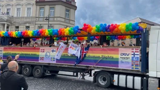 Vaivorykštės vėliavomis pasipuošę žmonės žygiuoja Vilniaus gatvėmis solidarumo akcijos metu.