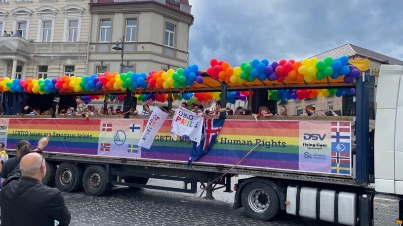 Vaivorykštės vėliavomis pasipuošę žmonės žygiuoja Vilniaus gatvėmis solidarumo akcijos metu.