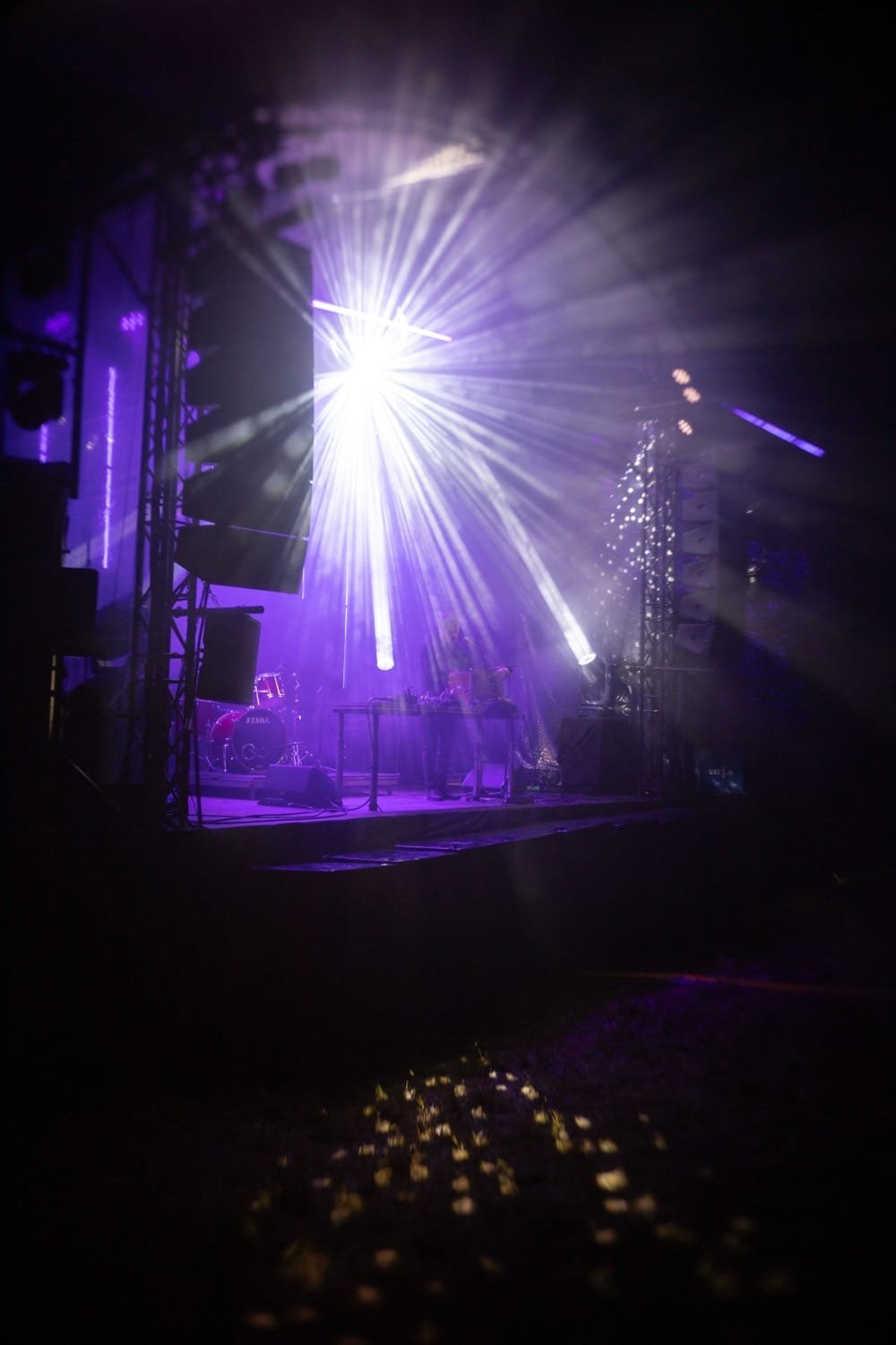 Atmosferinis elektroninės muzikos koncertas ir lazerių šviesos naktinėje scenoje.