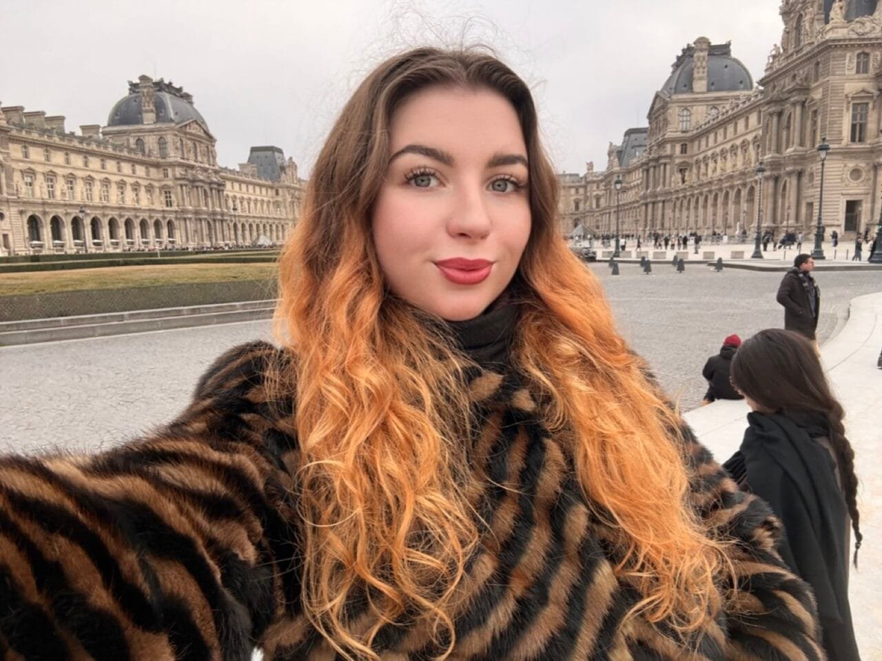 Turinio kūrėja Valerija Kozikaitė šypsosi pozuodama su knyga rankose, spinduliuojanti estetiką ir vidinę ramybę.