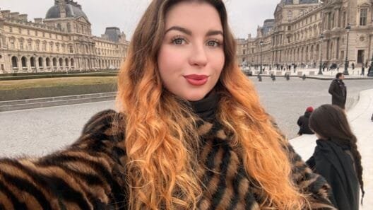 Turinio kūrėja Valerija Kozikaitė šypsosi pozuodama su knyga rankose, spinduliuojanti estetiką ir vidinę ramybę.