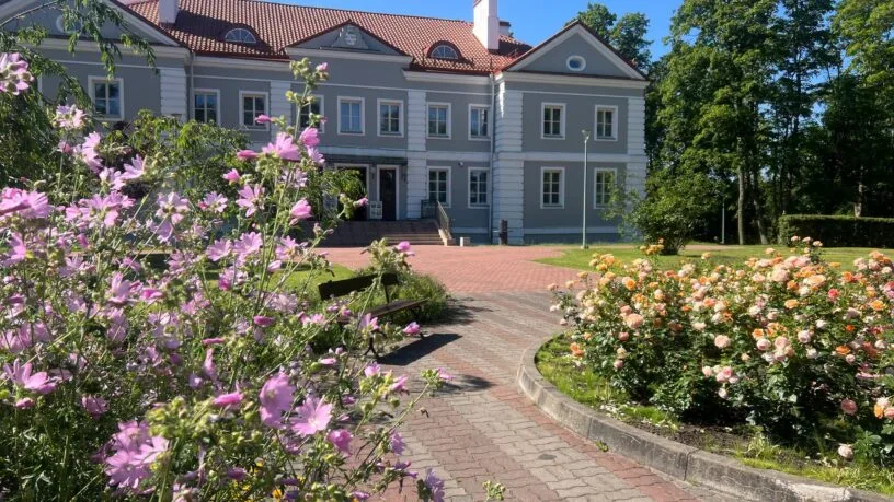 Lietuvos dvarai vasarą: Antazavės dvaro rūmai ir išpuoselėtas angliško stiliaus parkas saulėtą popietę.