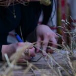 Rudens lygiadienis – šventės dalyviai rašo ant medinių kortelių, apsupti džiovintų žolynų.