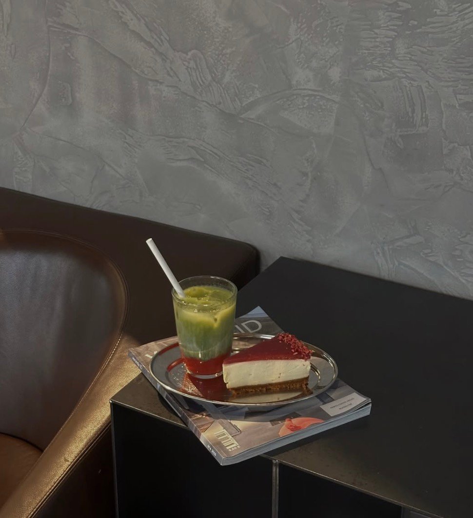 Matcha gėrimas ir pyrago gabalėlis ant žurnalo – stilingos kavinės Kaune akimirkos.