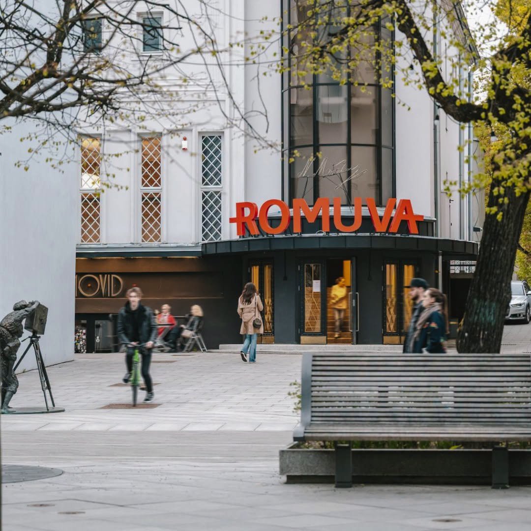 Kauno kino centro „Romuva“ fasadas su raudonu užrašu ir praeiviais.