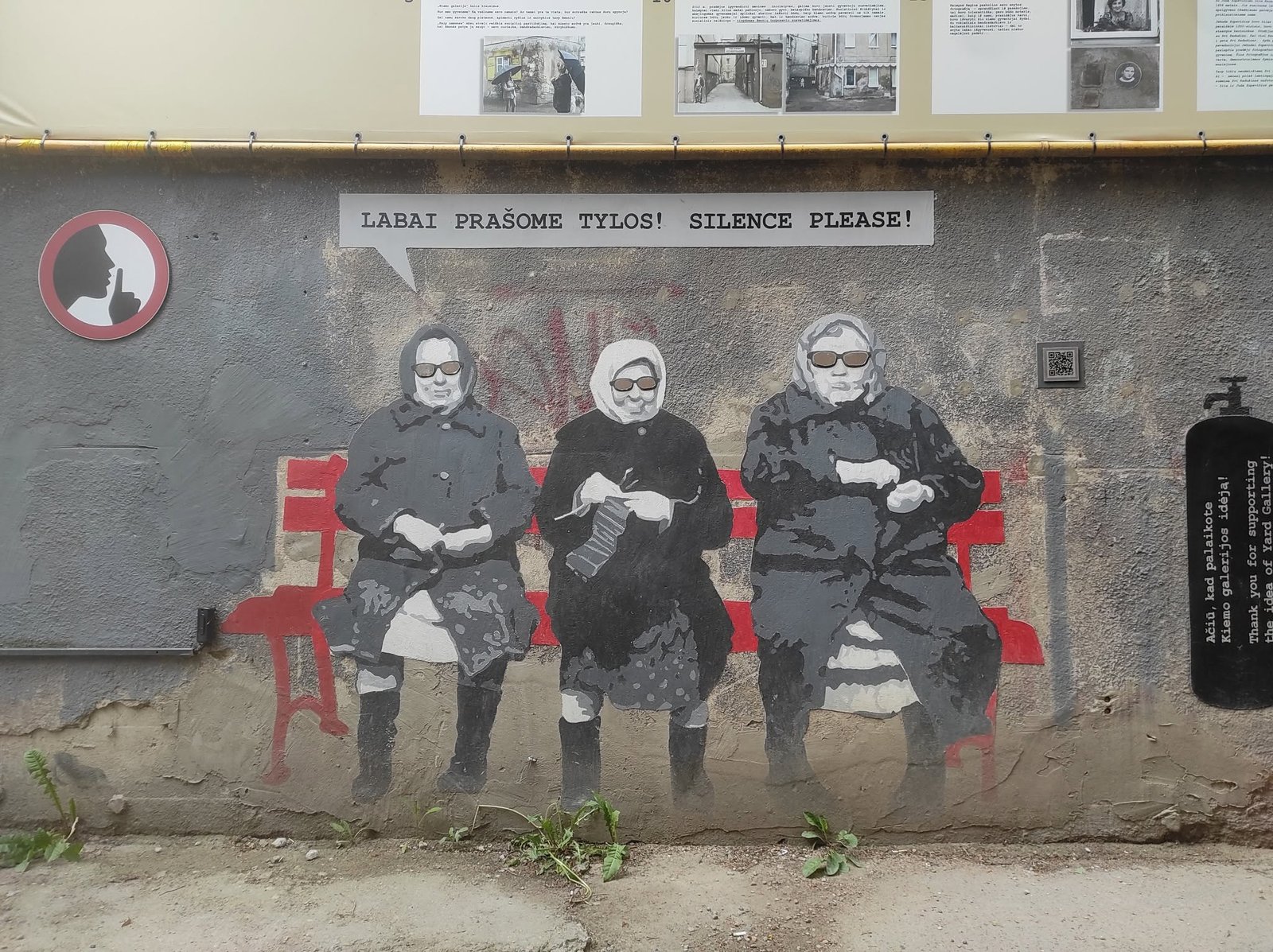 Sienos piešinys Kauno Kiemo galerijoje su senutėmis ir užrašu „Silence please“.