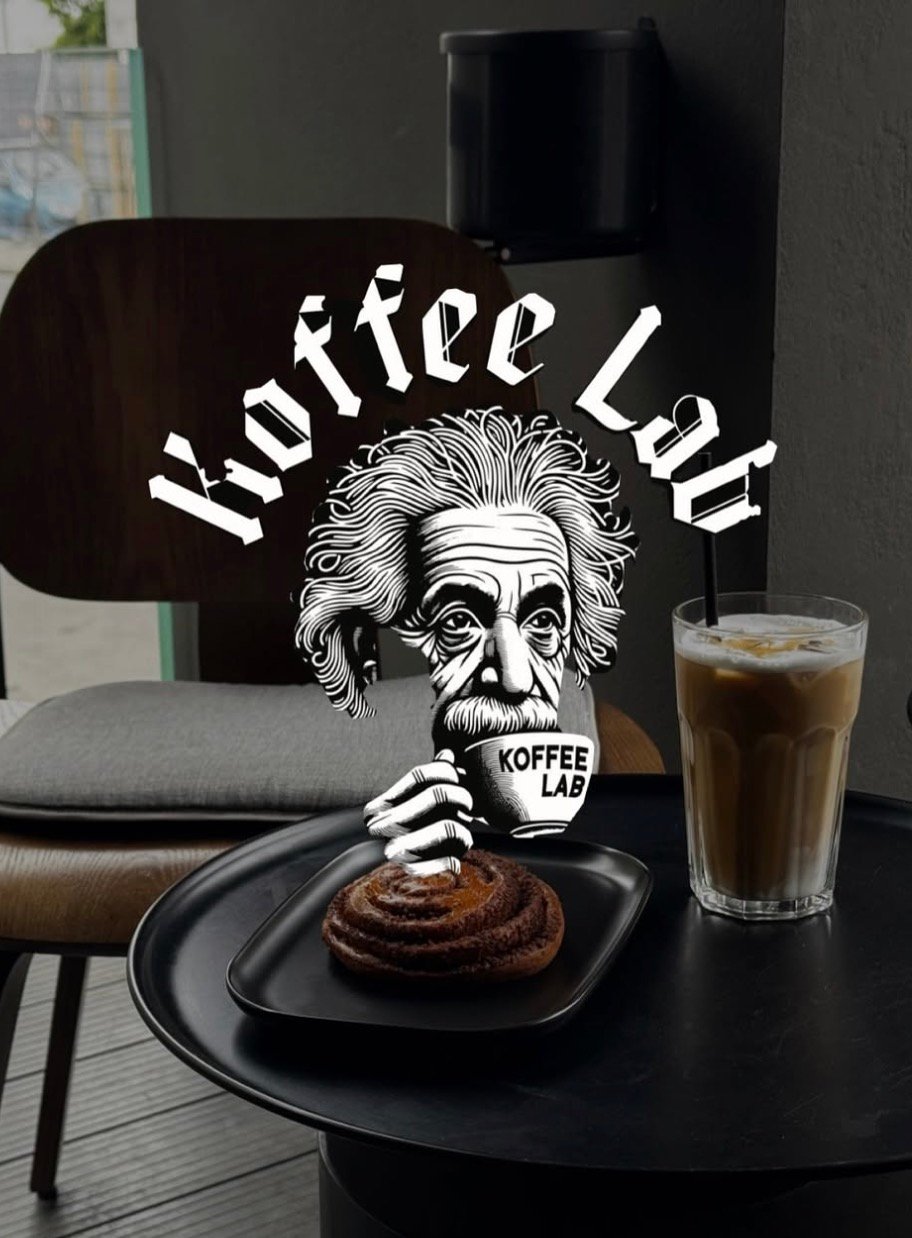 Šalta kava ir bandelė ant staliuko – jaukios kavinės Kaune „Koffee Lab“ akimirka.
