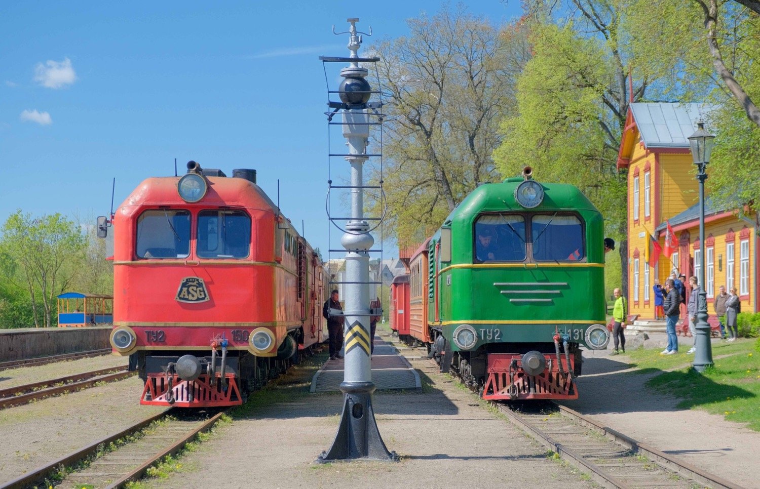 Siaurojo geležinkelio traukiniai Anykščių siauruko stotyje saulėtą dieną.