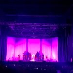 Violetinė šviesa apšviesta teatro scena su atlikėjais - spektakliai Vilniuje.