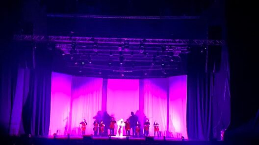Violetinė šviesa apšviesta teatro scena su atlikėjais - spektakliai Vilniuje.