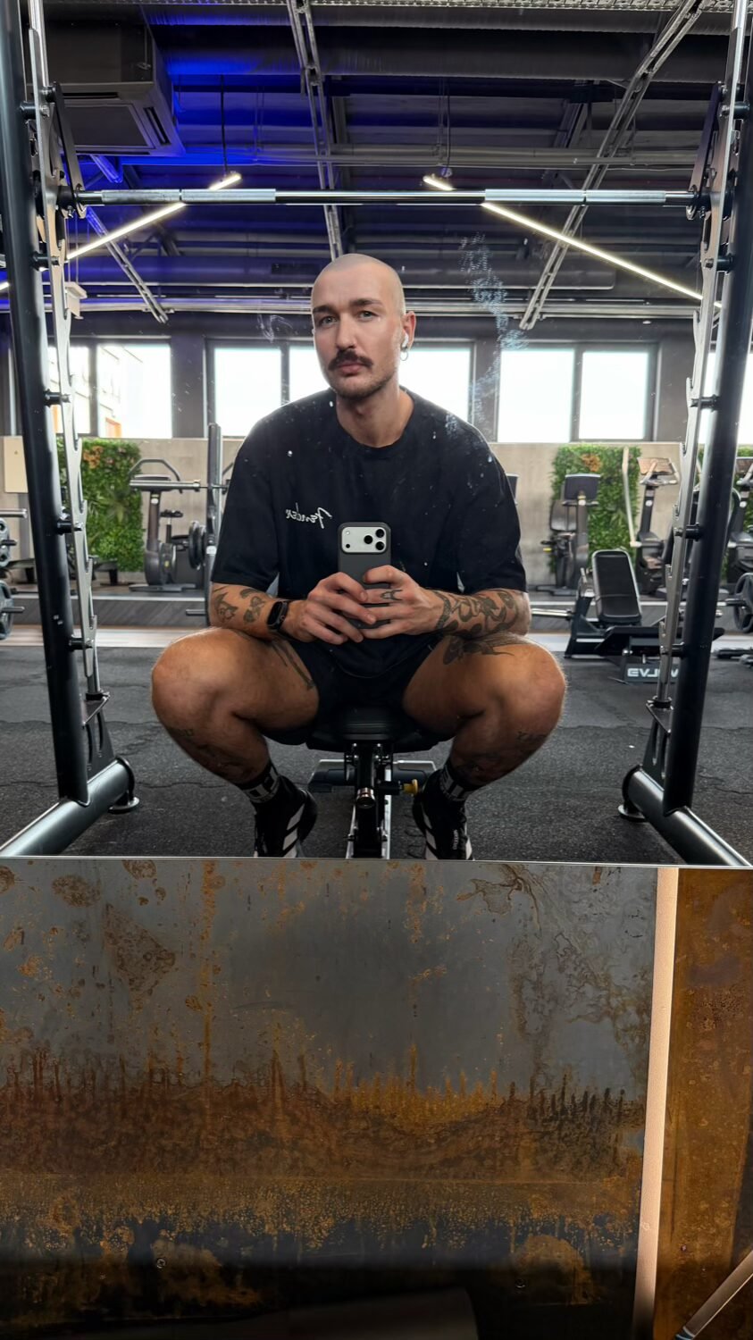 Vyras daro asmenukę veidrodyje sporto salėje
